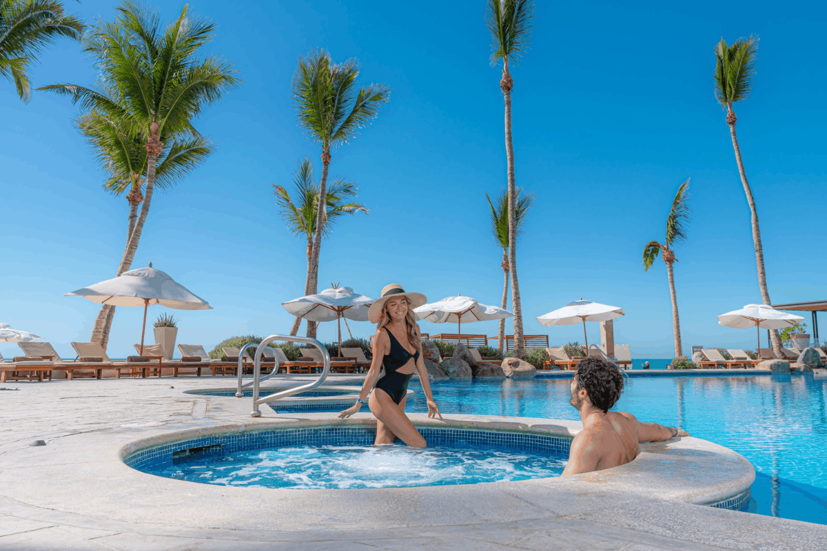 Jacuzzi pool at Krystal Grand Los Cabos with oceanfront views and palm trees.