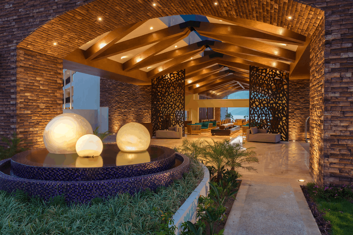 Main entrance of Krystal Grand Los Cabos at night with warm lighting and elegant architecture.