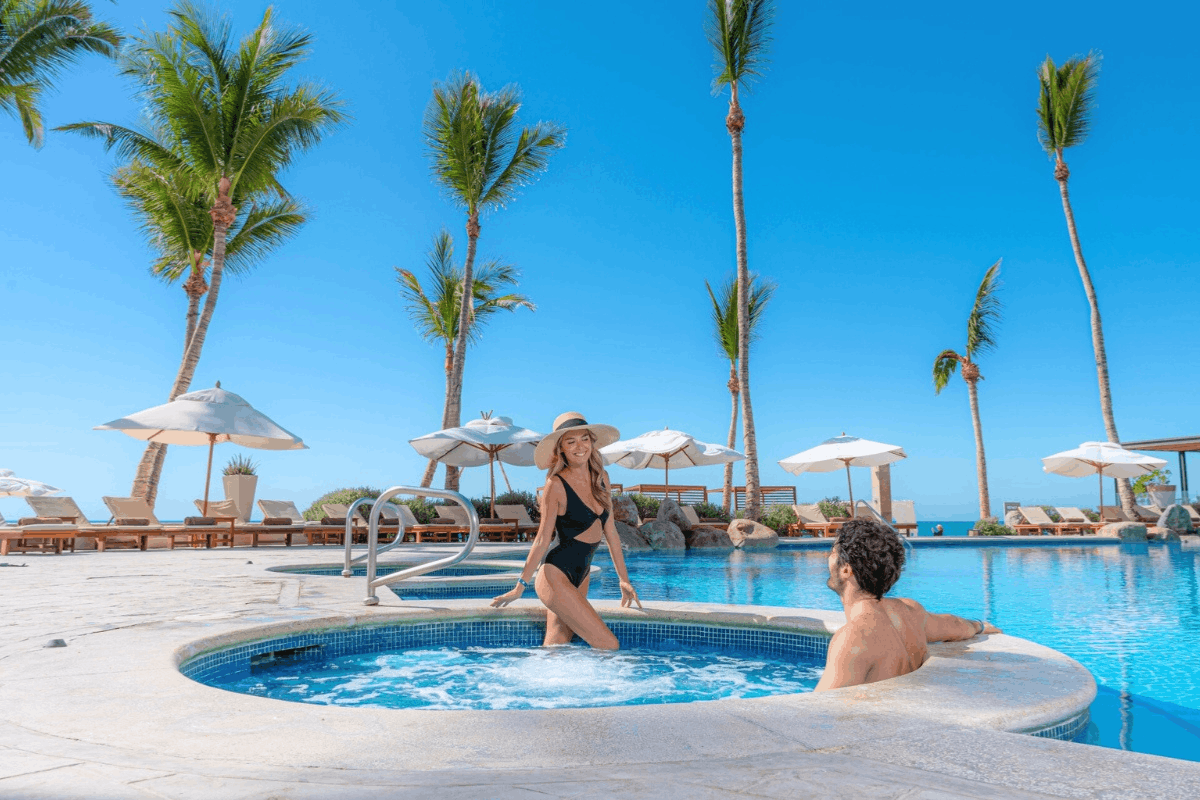 Oceanfront pools at Krystal Grand Los Cabos with jacuzzi, palm trees and relaxation areas